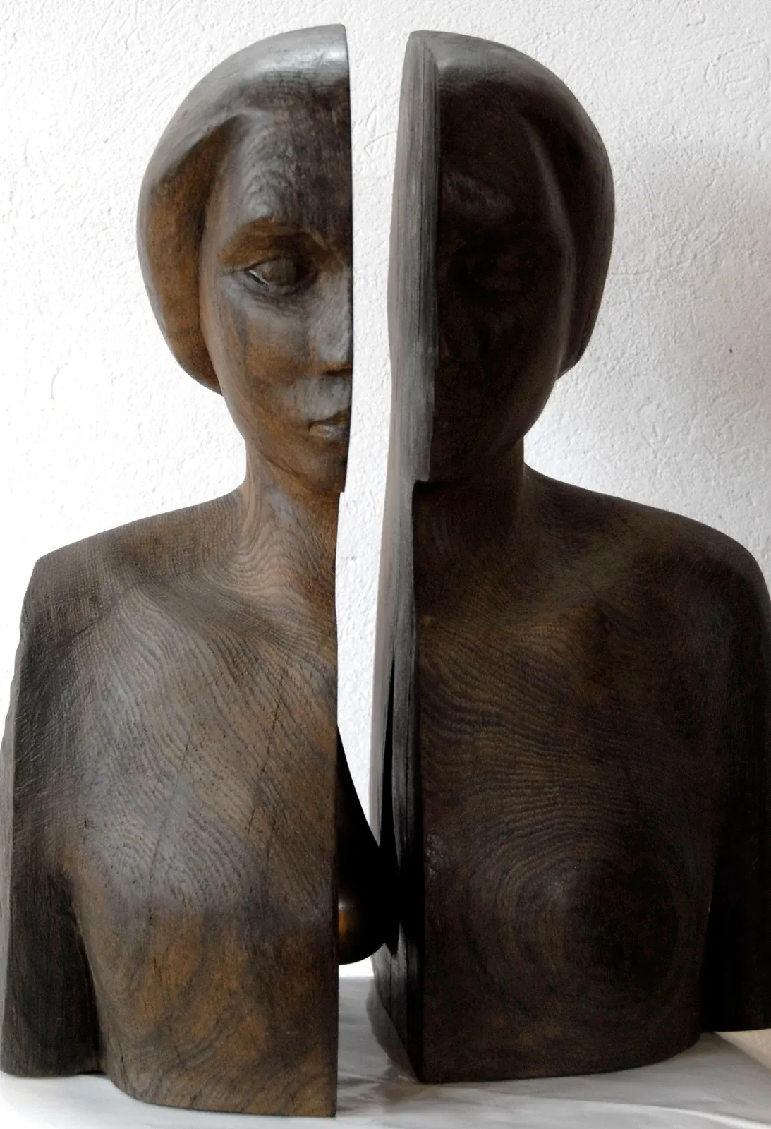 Nadzieja: busto femminile di rovere nero diviso verticalmente in due metà scostate; nel varco, all’altezza del petto, si intravede una sfera di bronzo