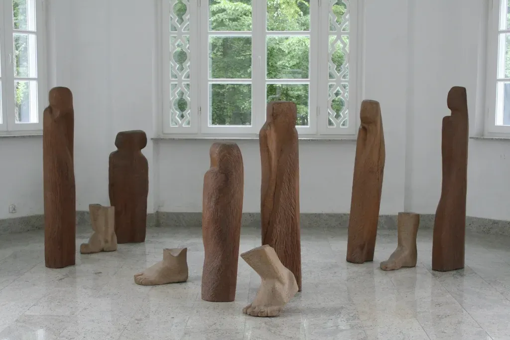 La galleria Oranżeria con «Wygnanie»: sei figure-stele di legno di altezze diverse e quattro grandi piedi scolpiti, posati sul pavimento di marmo davanti alle finestre.