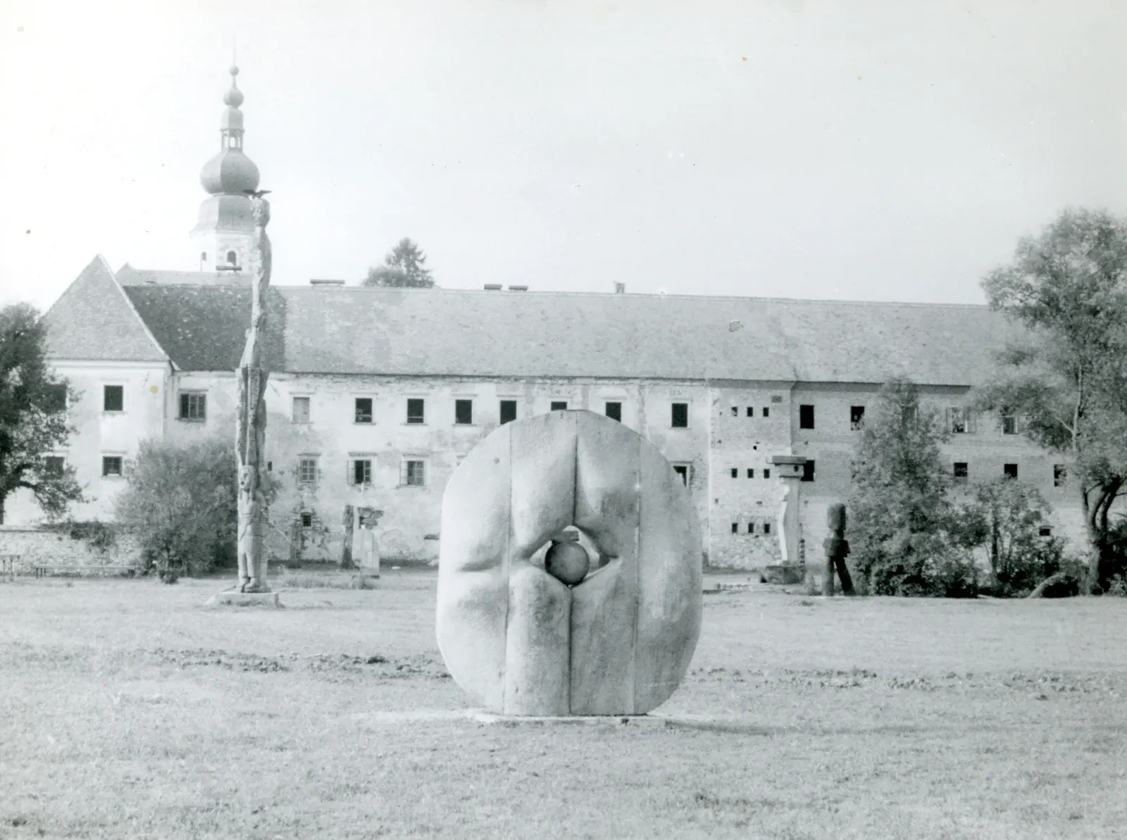 Sfera — La ripresa è l'opera nel prato davanti al monastero cistercense di Kostanjevica na Krki, sede di Forma Viva, con attorno le sculture di legno della collezione: è la sola veduta che dia il luogo per intero.