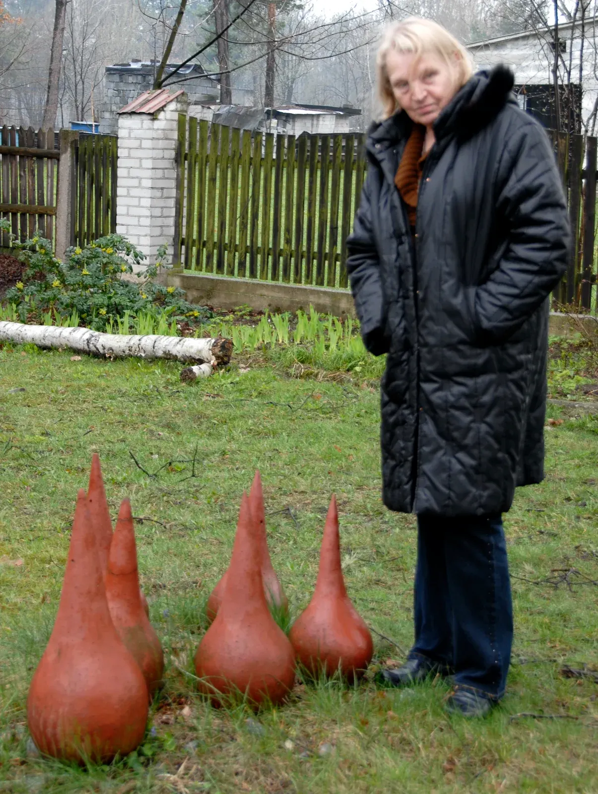 Łzy — Antonina in giardino accanto a 3 forme a goccia in terracotta