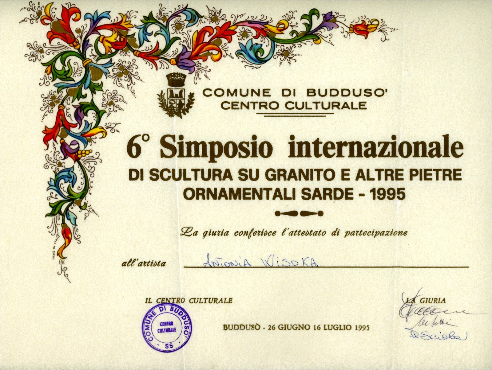 Attestato del 6° Simposio internazionale di scultura su granito di Buddusò, 1995, con fregio floreale a colori.